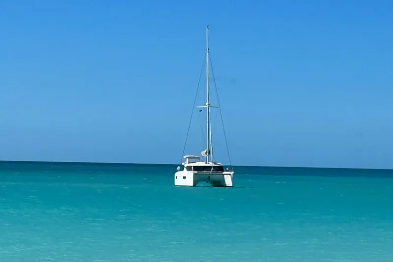 Sabai Sabai Yacht Photos Pics 2018 Fountaine Pajot Lucia 40 catamaran sailing on clear turquoise waters.