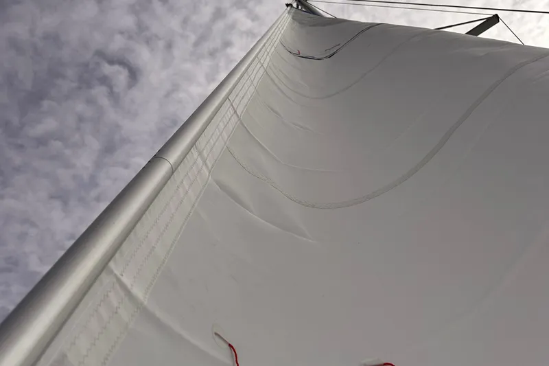 Sabai Sabai Yacht Photos Pics Close-up of a 2018 Fountaine Pajot Lucia 40 sail against a cloudy sky.