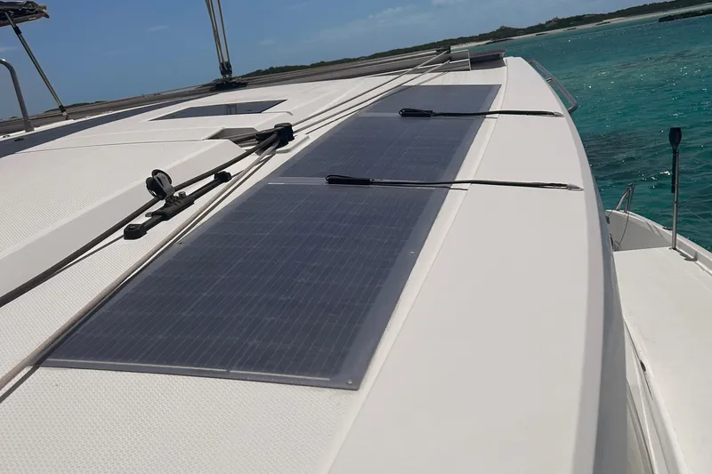 Sabai Sabai Yacht Photos Pics 2018 Fountaine Pajot Lucia 40 catamaran with solar panels on deck, sailing in clear waters.