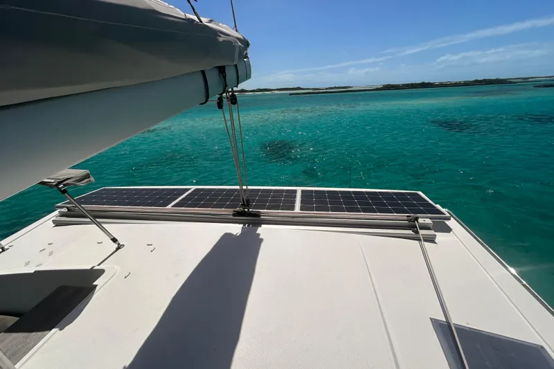 Sabai Sabai Yacht Photos Pics Fountaine Pajot Lucia 40 catamaran with solar panels, sailing on clear turquoise waters.