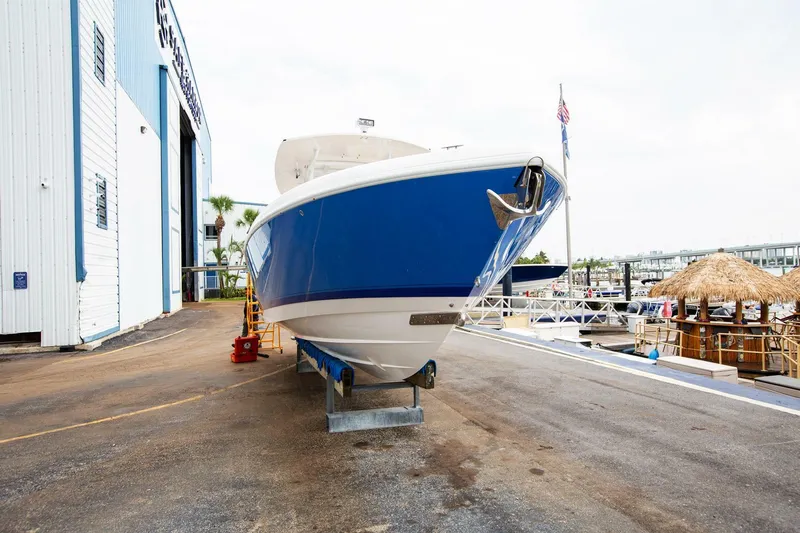  Yacht Photos Pics 2011 Intrepid 32 boat in dry dock, blue hull, marina background.