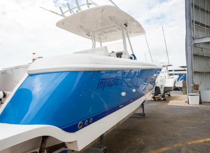  Yacht Photos Pics 2011 Intrepid 32 boat with blue hull, docked in a marina.