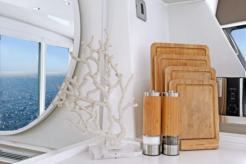 Crystal Dreams Yacht Photos Pics Modern yacht kitchen with ocean view, featuring bamboo cutting boards and coral decor.