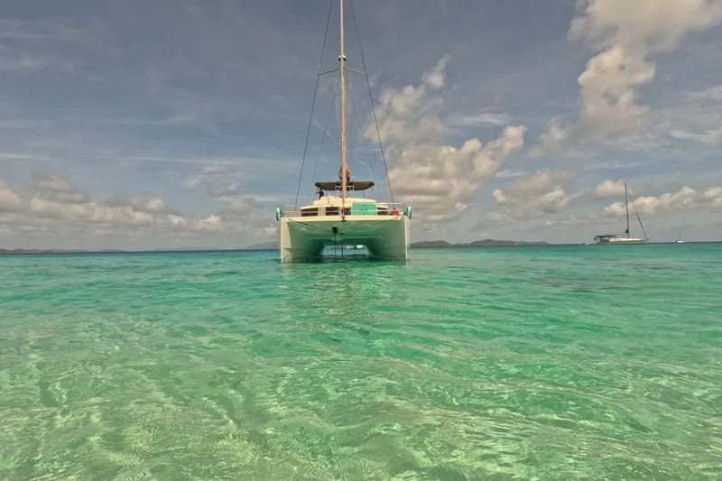 Crystal Dreams Yacht Photos Pics 2022 Bali 5.4 catamaran on clear turquoise water under a partly cloudy sky.