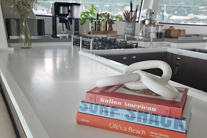 Crystal Dreams Yacht Photos Pics Modern yacht kitchen with books and decor on a sleek countertop, Bali 5.4, 2022 model.
