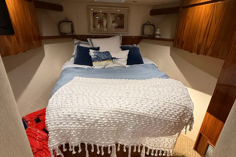 62025 Yacht Photos Pics Cozy bedroom in 2016 Viking 62 Convertible yacht with plush bedding and wooden accents.