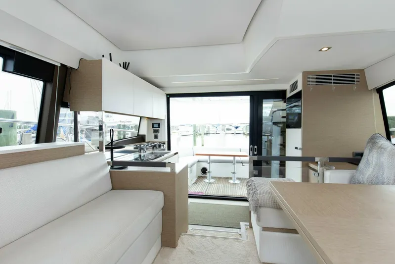 Pass-n-bye Yacht Photos Pics Luxurious interior of 2023 Prestige 460 Flybridge yacht with modern kitchen and seating area.
