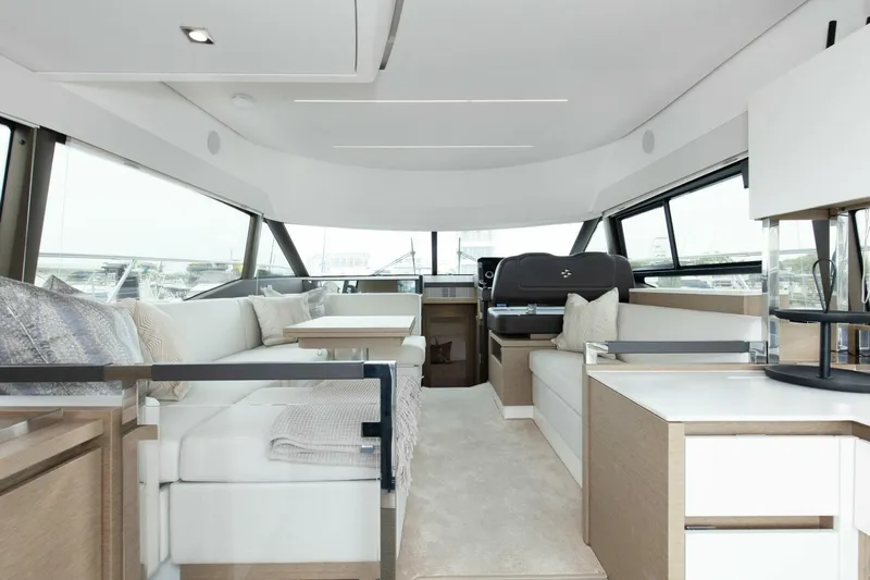 Pass-n-bye Yacht Photos Pics Luxurious interior of 2023 Prestige 460 Flybridge yacht with modern seating and panoramic windows.