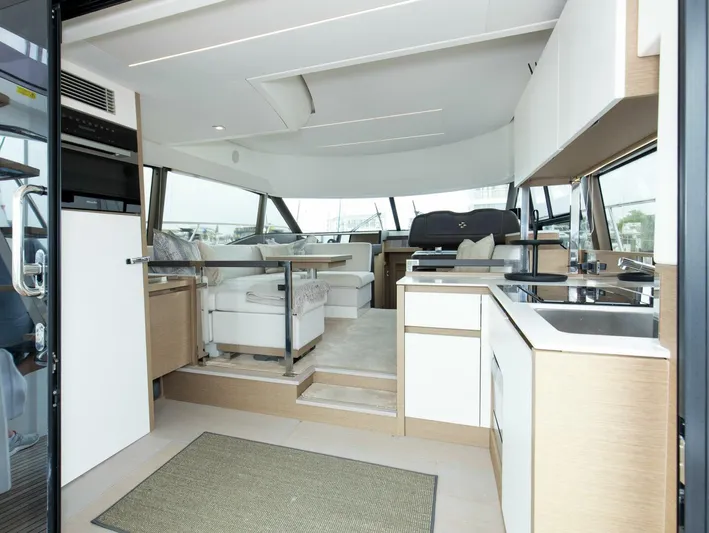 Pass-n-bye Yacht Photos Pics Luxurious interior of 2023 Prestige 460 Flybridge yacht with modern kitchen and seating area.