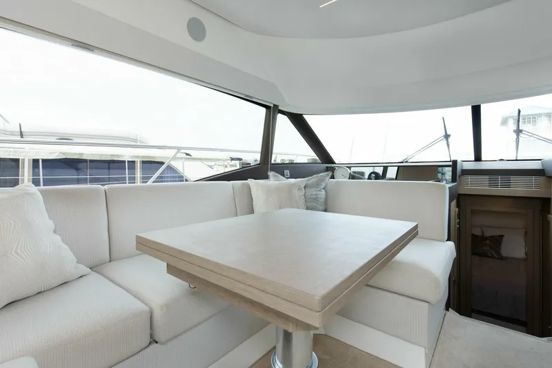 Pass-n-bye Yacht Photos Pics Luxurious interior of 2023 Prestige 460 Flybridge yacht with elegant seating and table.
