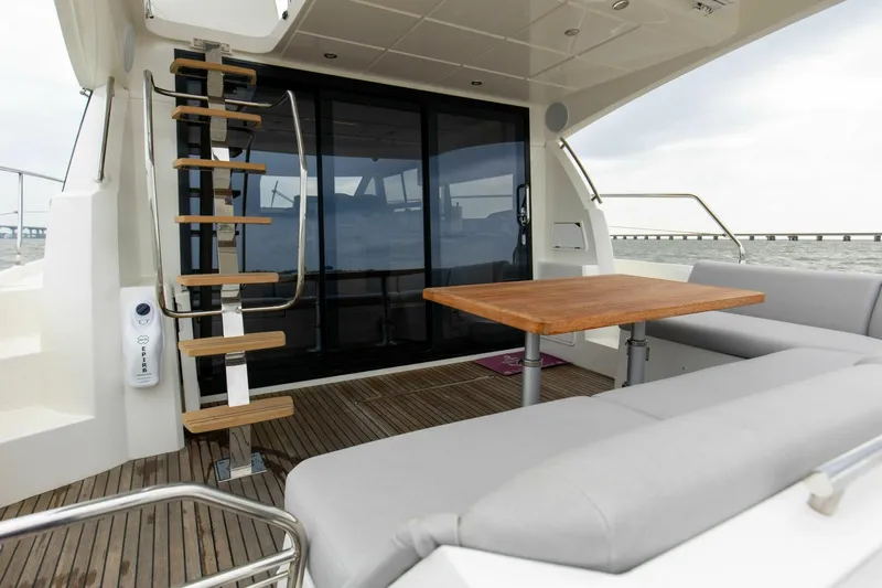 Pass-n-bye Yacht Photos Pics Prestige 460 Flybridge 2023 yacht deck with seating, table, and staircase.