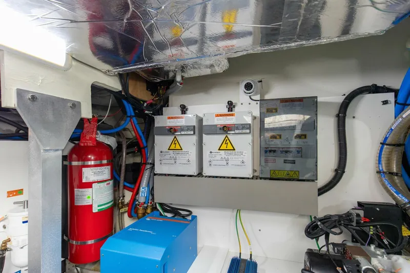 Pass-n-bye Yacht Photos Pics Engine room of 2023 Prestige 460 Flybridge yacht with electrical panels and fire extinguisher.
