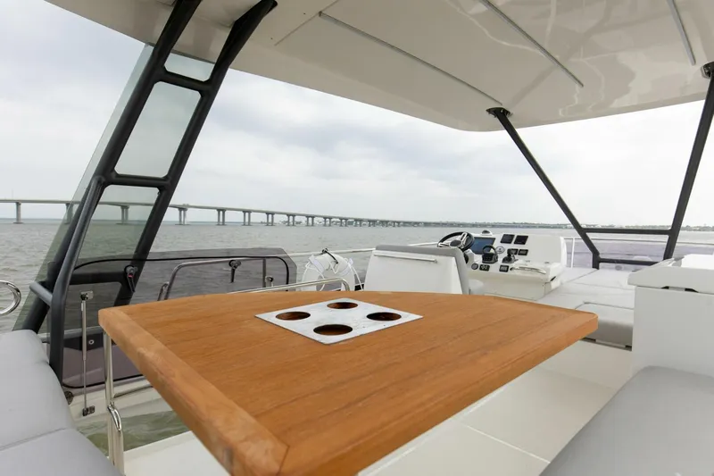 Pass-n-bye Yacht Photos Pics Prestige 460 Flybridge 2023 yacht interior with wooden table and ocean view.