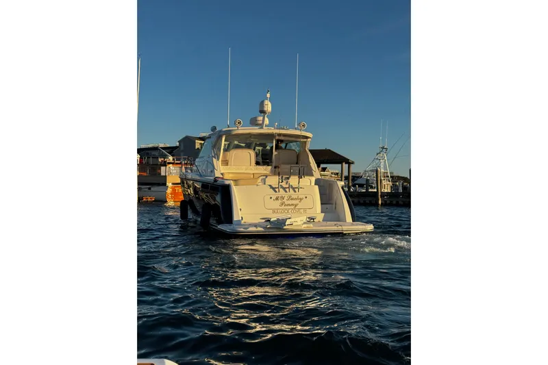 My Lucky Penny Yacht Photos Pics 2006 Tiara Yachts 4300 Sovran on water near docks at sunset.