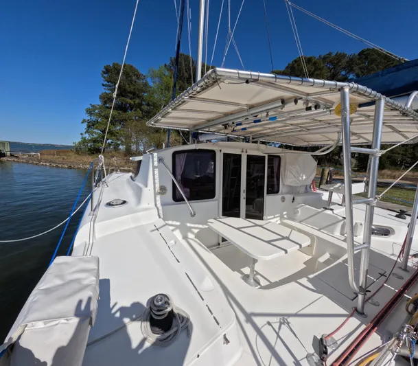 Quelle Belle Vie Yacht Photos Pics 2008 Fountaine Pajot Mahe 36 catamaran with spacious deck and canopy, docked by the shore.