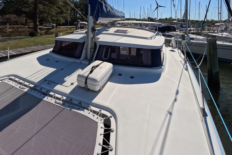 Quelle Belle Vie Yacht Photos Pics 2008 Fountaine Pajot Mahe 36 catamaran docked at a marina, featuring spacious deck and netting.