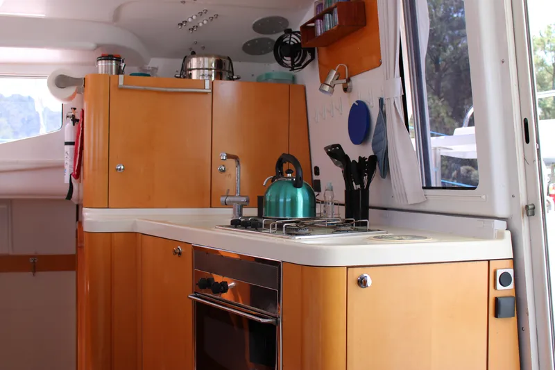 Quelle Belle Vie Yacht Photos Pics Interior of 2008 Fountaine Pajot Mahe 36 yacht kitchen with stove and cabinets.