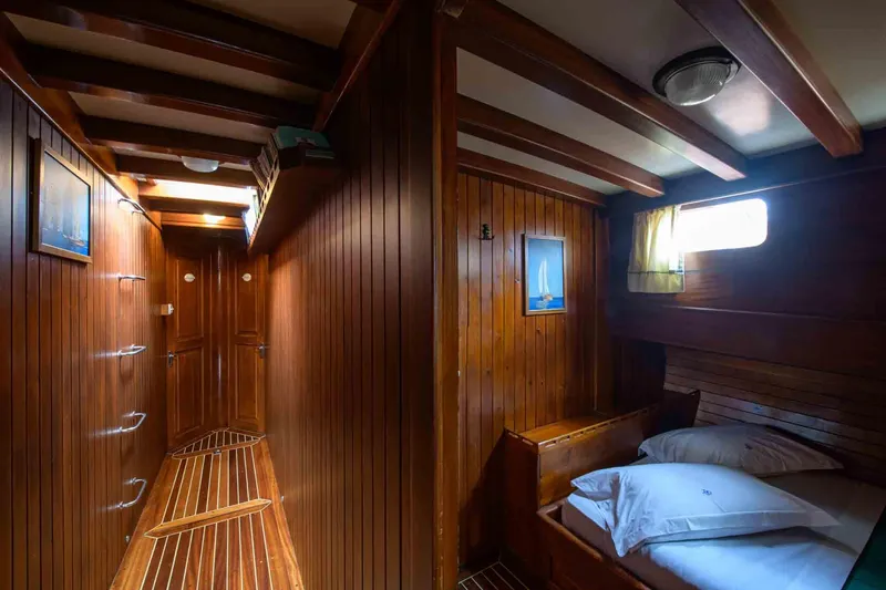  Yacht Photos Pics Wood-paneled cabin interior of 2006 Classic Caicco ERDAL SOGUTCUK yacht, featuring cozy bed and hallway.