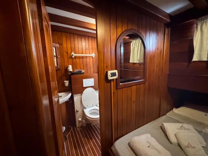  Yacht Photos Pics Wood-paneled bathroom and bedroom on 2006 Classic Caicco ERDAL SOGUTCUK yacht, featuring cozy amenities.