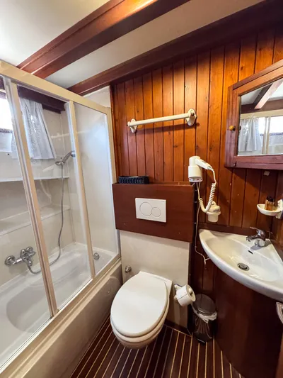  Yacht Photos Pics Wood-paneled bathroom on 2006 Classic Caicco ERDAL SOGUTCUK yacht with shower, toilet, and sink.