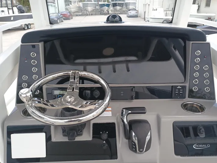 266 -105 Yacht Photos Pics 2023 Robalo 266 Cayman SD boat dashboard with steering wheel and control panel.