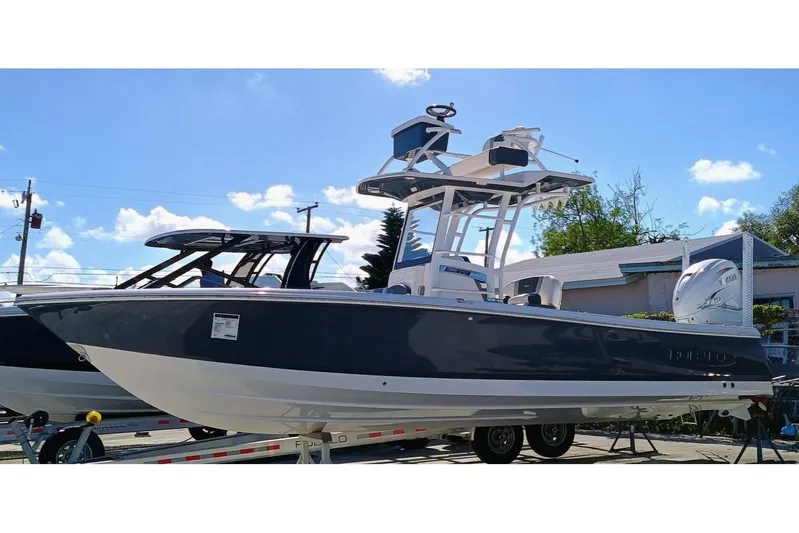 266 -105 Yacht Photos Pics 2023 Robalo 266 Cayman SD boat on trailer under clear blue sky.