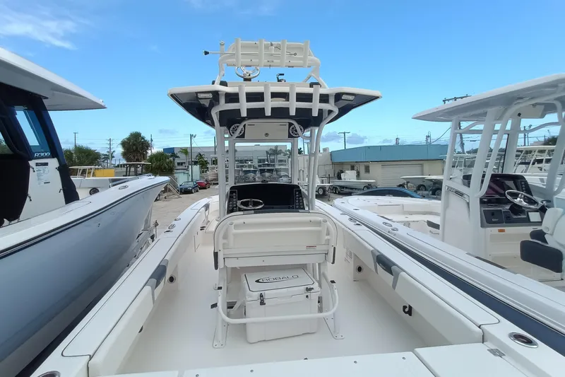 266 -105 Yacht Photos Pics 2023 Robalo 266 Cayman SD boat with center console and T-top in a marina setting.