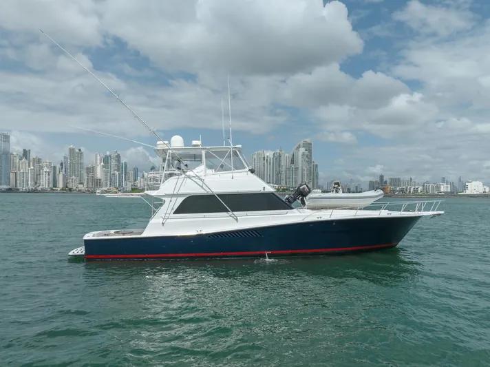 Tam Tam Yacht Photos Pics 1997 Viking 58 Convertible yacht on water with city skyline background.