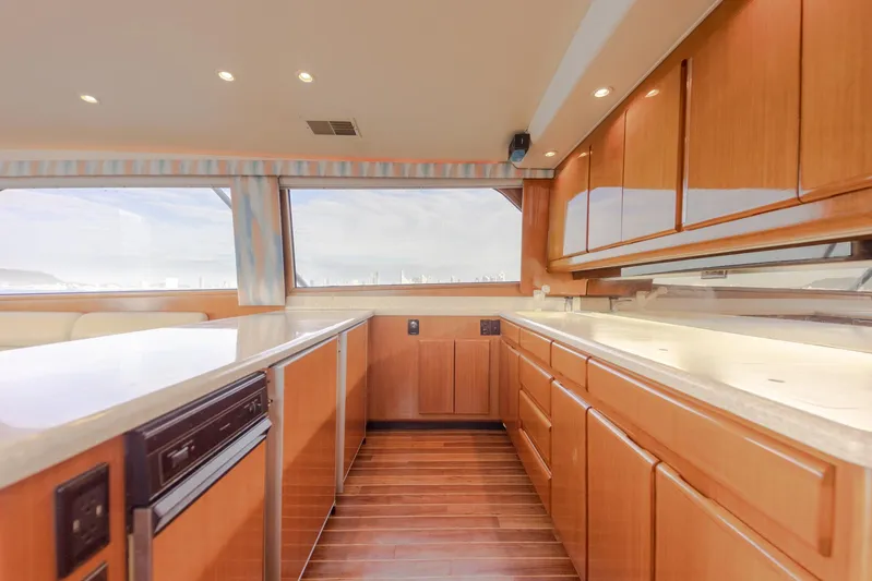 Tam Tam Yacht Photos Pics Interior kitchen of 1997 Viking 58 Convertible yacht with wooden cabinets and large windows.