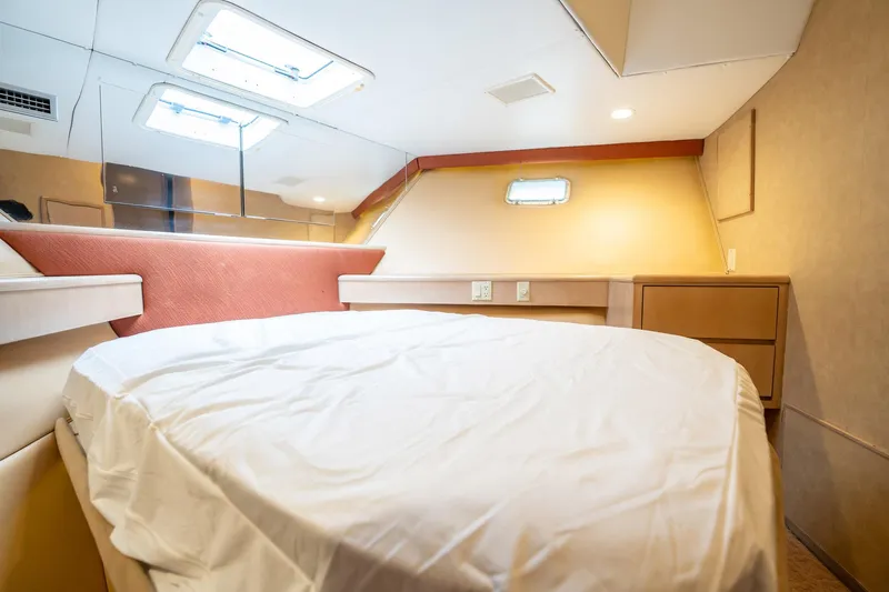 Hatts Off Yacht Photos Pics Interior cabin of 1998 Hatteras 74 Cockpit Motor Yacht with bed and porthole.