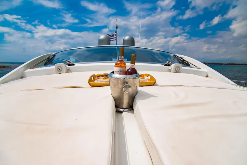  Yacht Photos Pics Luxury Pershing 65 yacht deck with drinks, 2003 model, under a vibrant blue sky.