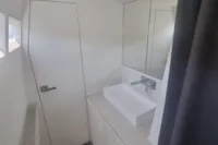 Modern bathroom interior on a 2023 Custom 22m Catamaran, featuring sleek design and fixtures.