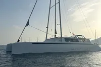 2023 Custom 22m Catamaran sailing on calm waters at sunset.