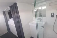 Modern bathroom and sleeping area in 2023 Custom 22m Catamaran.