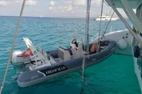 A 2023 Custom 22m Catamaran with a Highfield tender in turquoise waters.