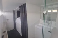 Interior of 2023 Custom 22m Catamaran with modern bathroom and cozy sleeping area.