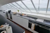 Modern kitchen interior on a 2023 Custom 22m Catamaran with ocean view.