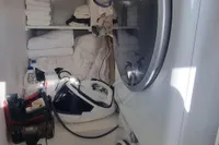 Laundry room on a 2023 Custom 22m Catamaran with stacked washer and dryer.