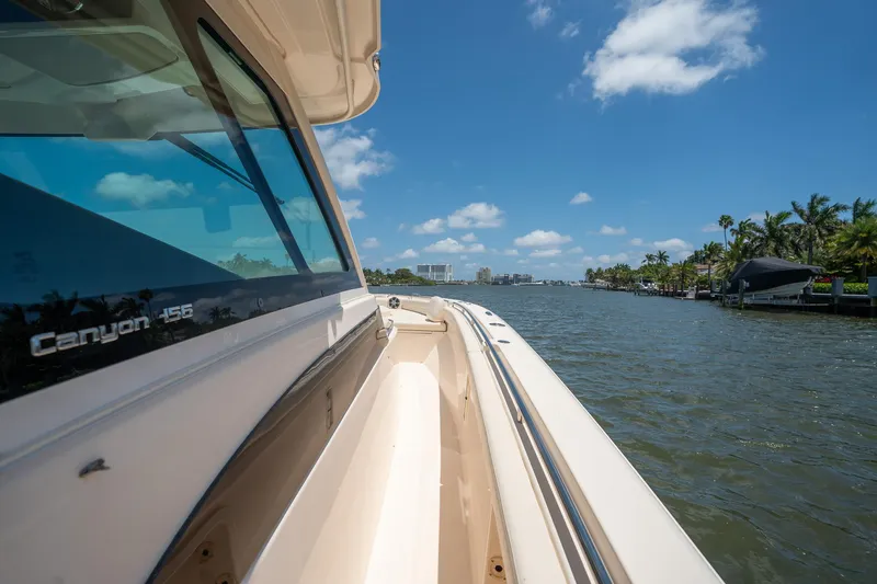  Yacht Photos Pics 2019 Grady-White Canyon 456 boat cruising on a sunny waterway.