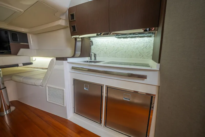  Yacht Photos Pics 2019 Grady-White Canyon 456 interior with kitchenette, featuring sink and stainless steel appliances.