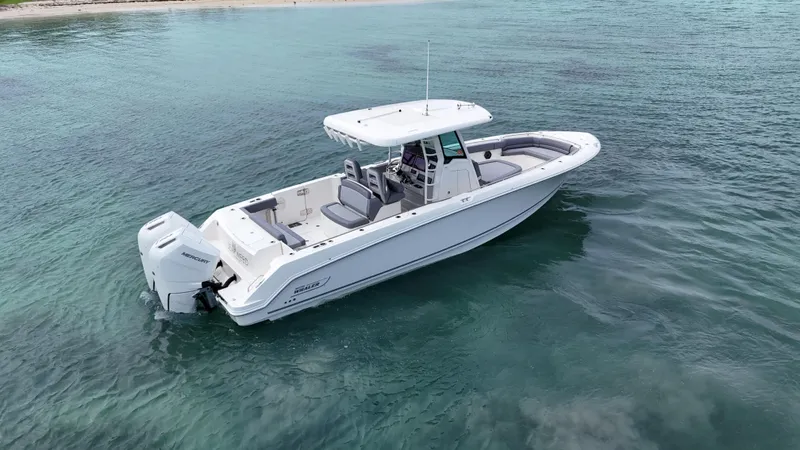  Yacht Photos Pics 2025 Boston Whaler 330 Outrage boat on clear water, showcasing sleek design and powerful engine.