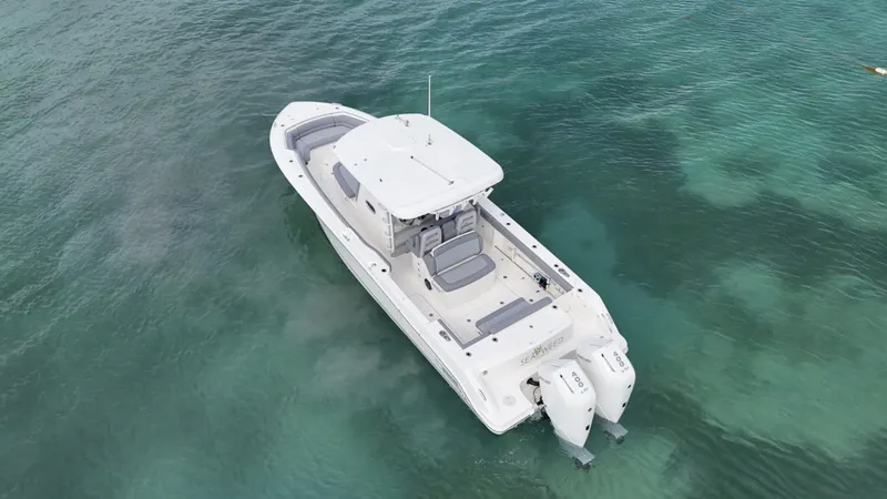  Yacht Photos Pics 2025 Boston Whaler 330 Outrage boat on clear turquoise water, aerial view.