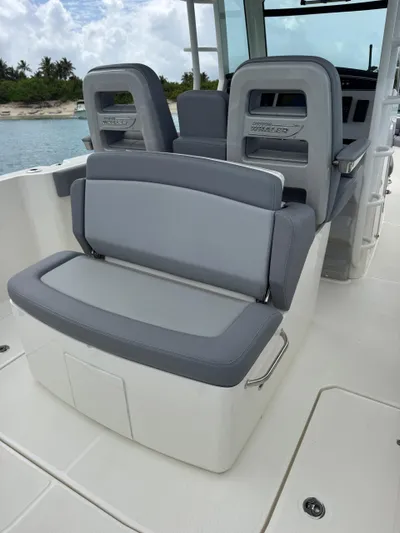  Yacht Photos Pics 2025 Boston Whaler 330 Outrage boat interior with gray seating and ocean backdrop.