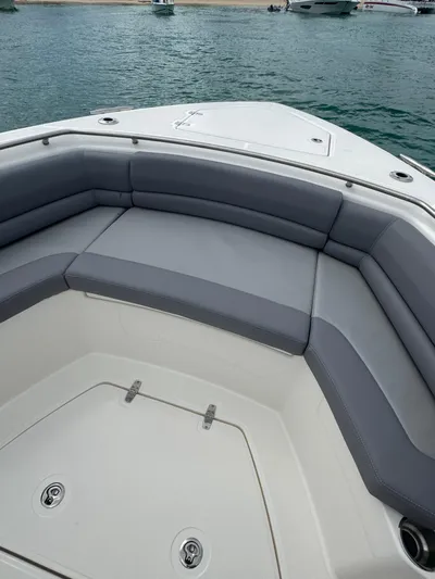  Yacht Photos Pics 2025 Boston Whaler 330 Outrage boat with spacious seating, docked on calm waters.