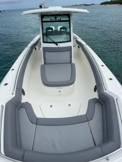  Yacht Photos Pics 2025 Boston Whaler 330 Outrage boat with sleek seating, on calm water.