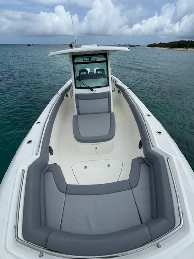  Yacht Photos Pics 2025 Boston Whaler 330 Outrage boat with sleek design on calm waters.