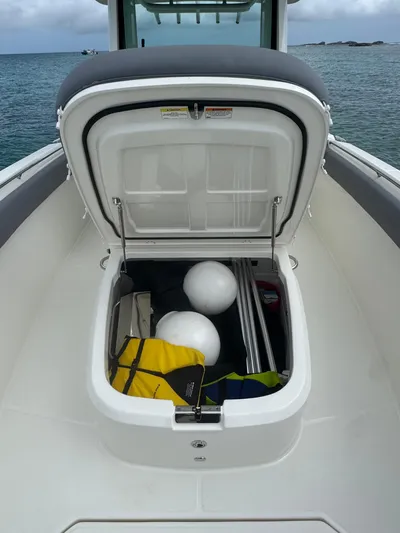  Yacht Photos Pics 2025 Boston Whaler 330 Outrage storage compartment with marine equipment and accessories.