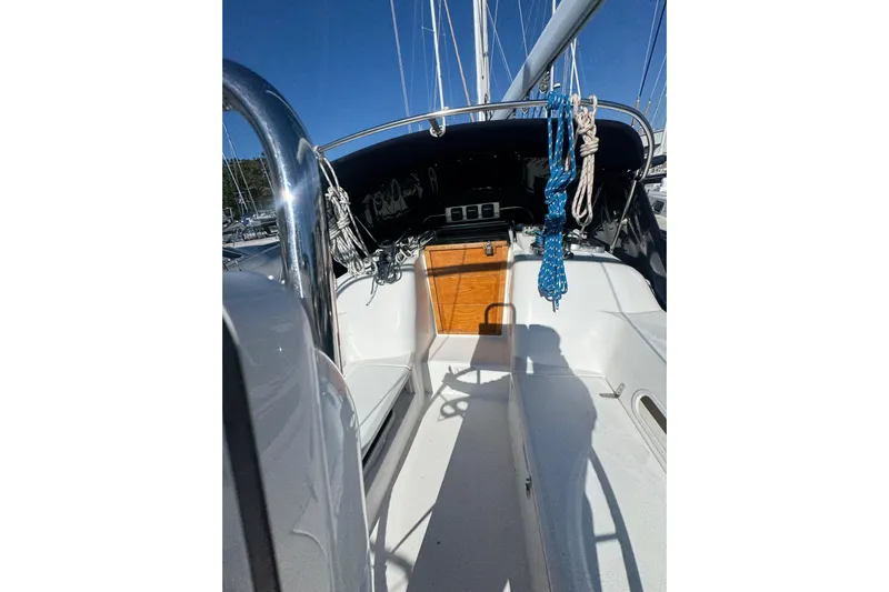 Lady Slipper Yacht Photos Pics 2005 Sabre 386 sailboat cockpit with ropes and wooden hatch under clear blue sky.