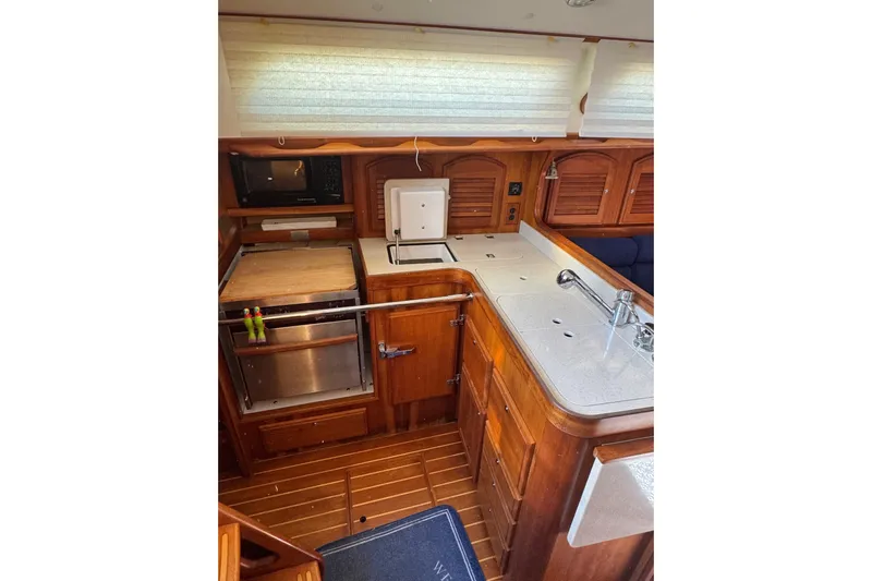 Lady Slipper Yacht Photos Pics 2005 Sabre 386 yacht interior kitchen with wooden cabinetry and modern appliances.