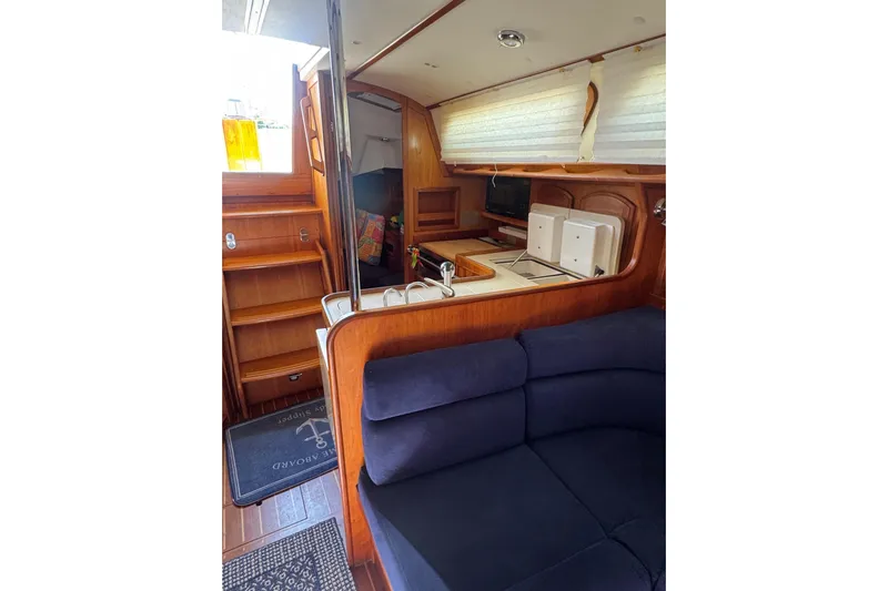 Lady Slipper Yacht Photos Pics Interior of 2005 Sabre 386 yacht with wooden cabinetry and blue seating.